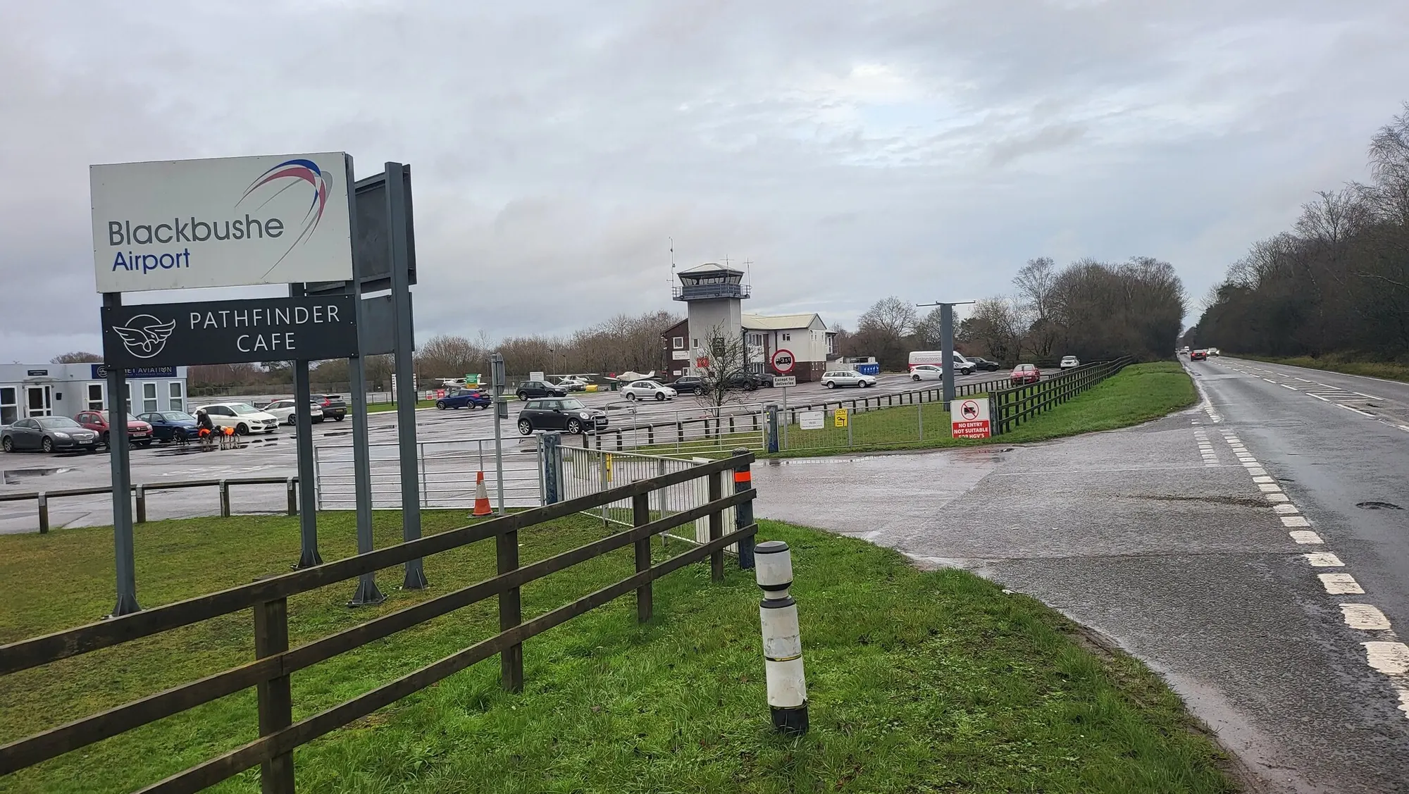 Blackbushe Airport A30 entrance, sign, car park and control tower photographed in January 2022