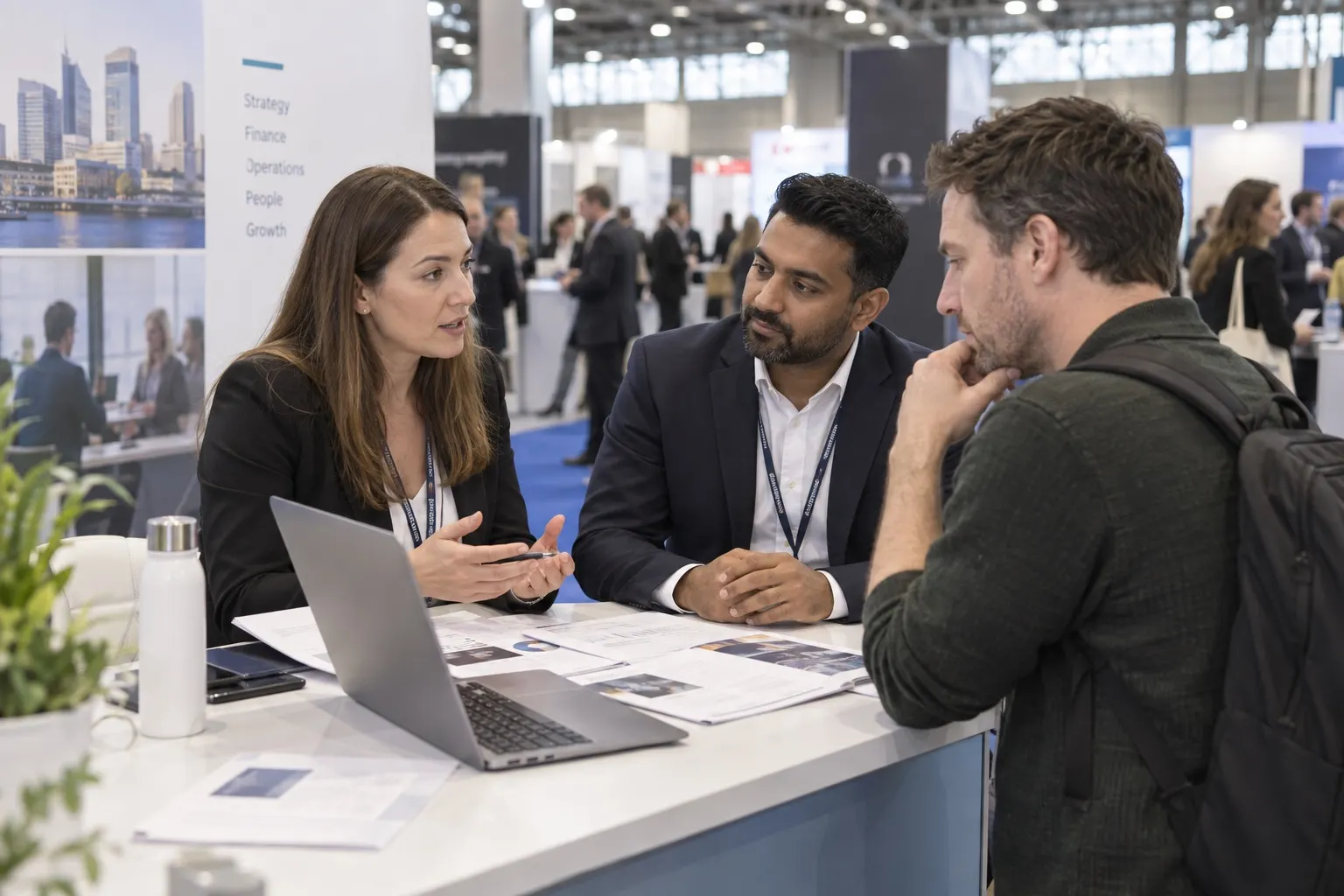 Illustrative founder discussing business planning with advisers at a trade stand
