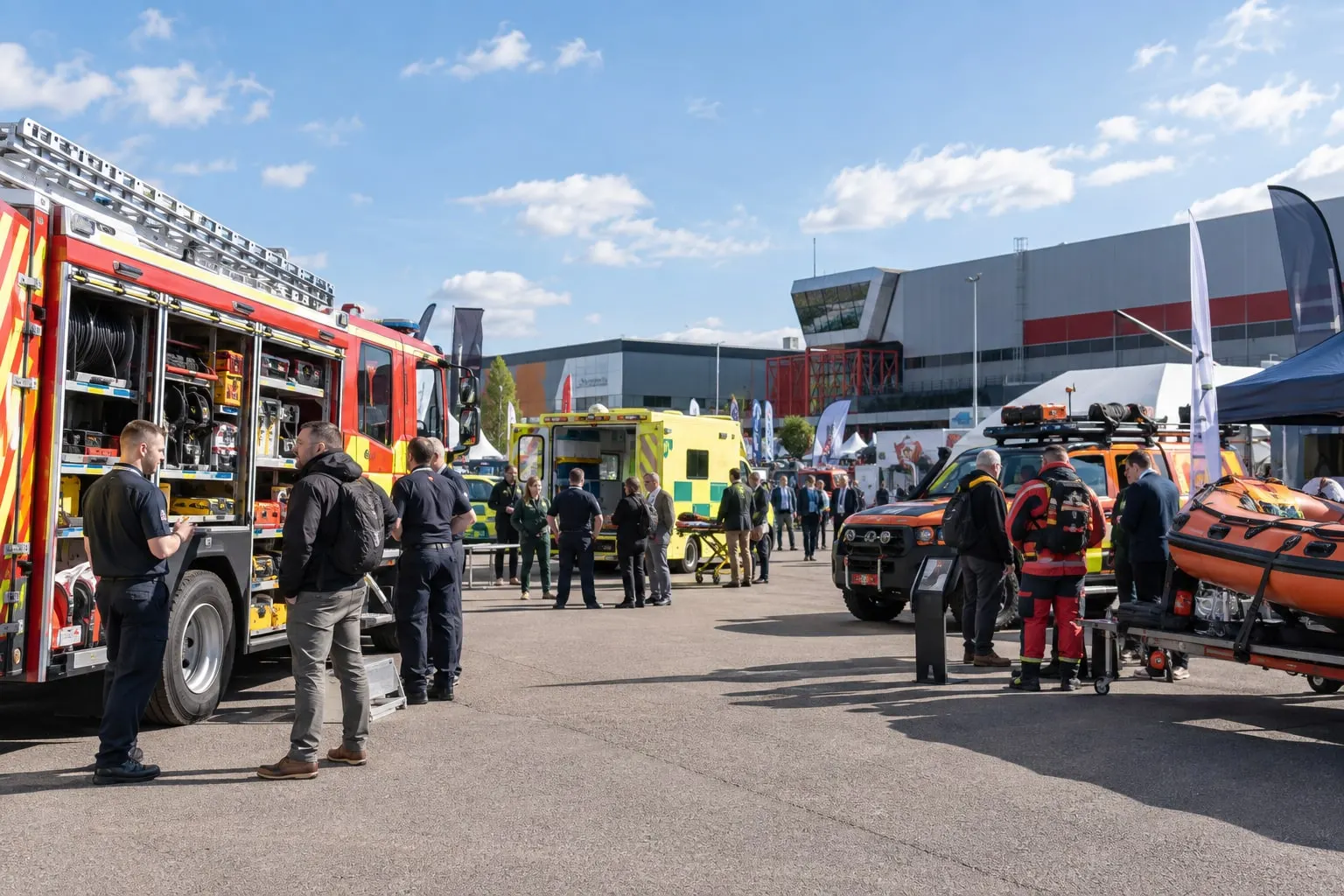 Illustrative outdoor emergency-vehicle exhibition area beside a Birmingham exhibition hall
