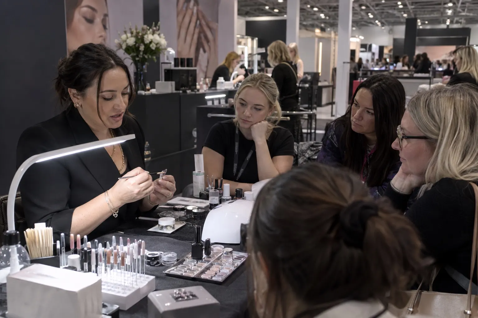 Illustrative professional nail educator demonstrating techniques to beauty trade delegates