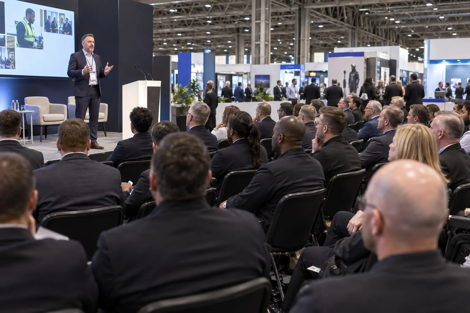Illustrative professional security officers attending a guarding-industry talk at the NEC