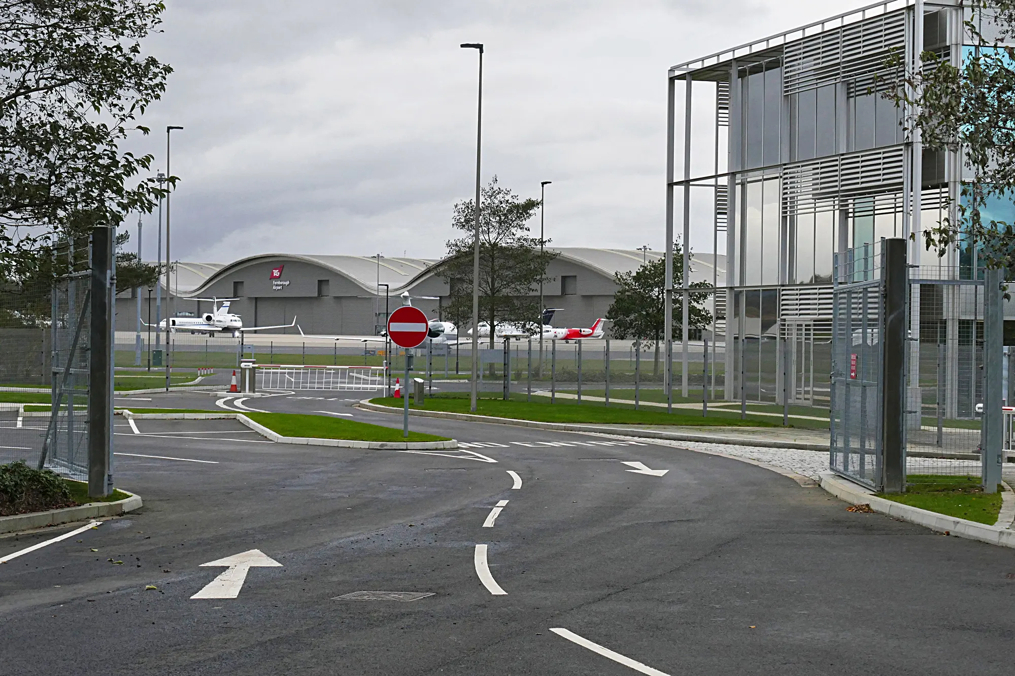 Farnborough Airport perimeter entrance, hangars and business aircraft photographed in November 2015