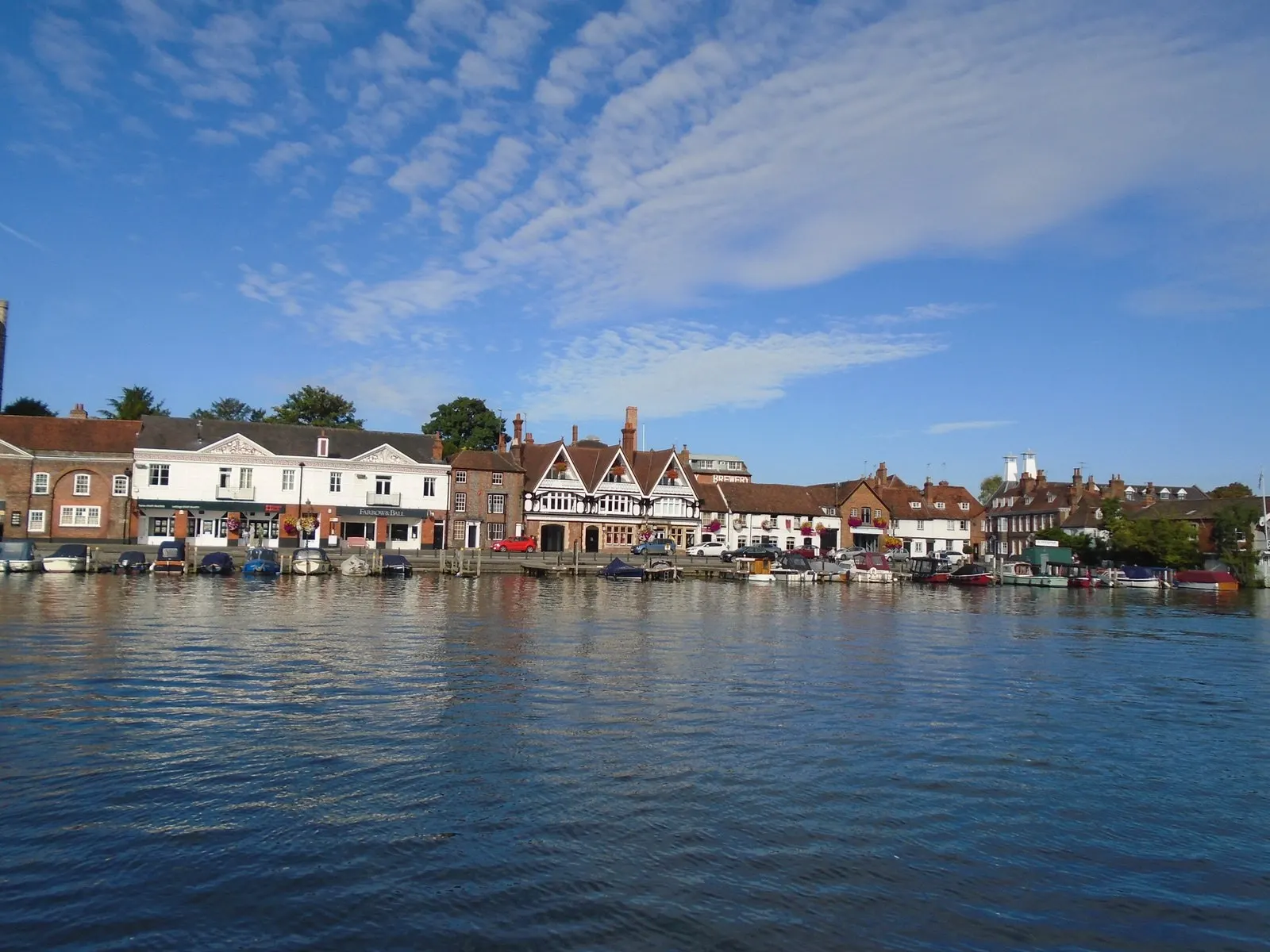 Boats moored beside Henley-on-Thames waterfront buildings