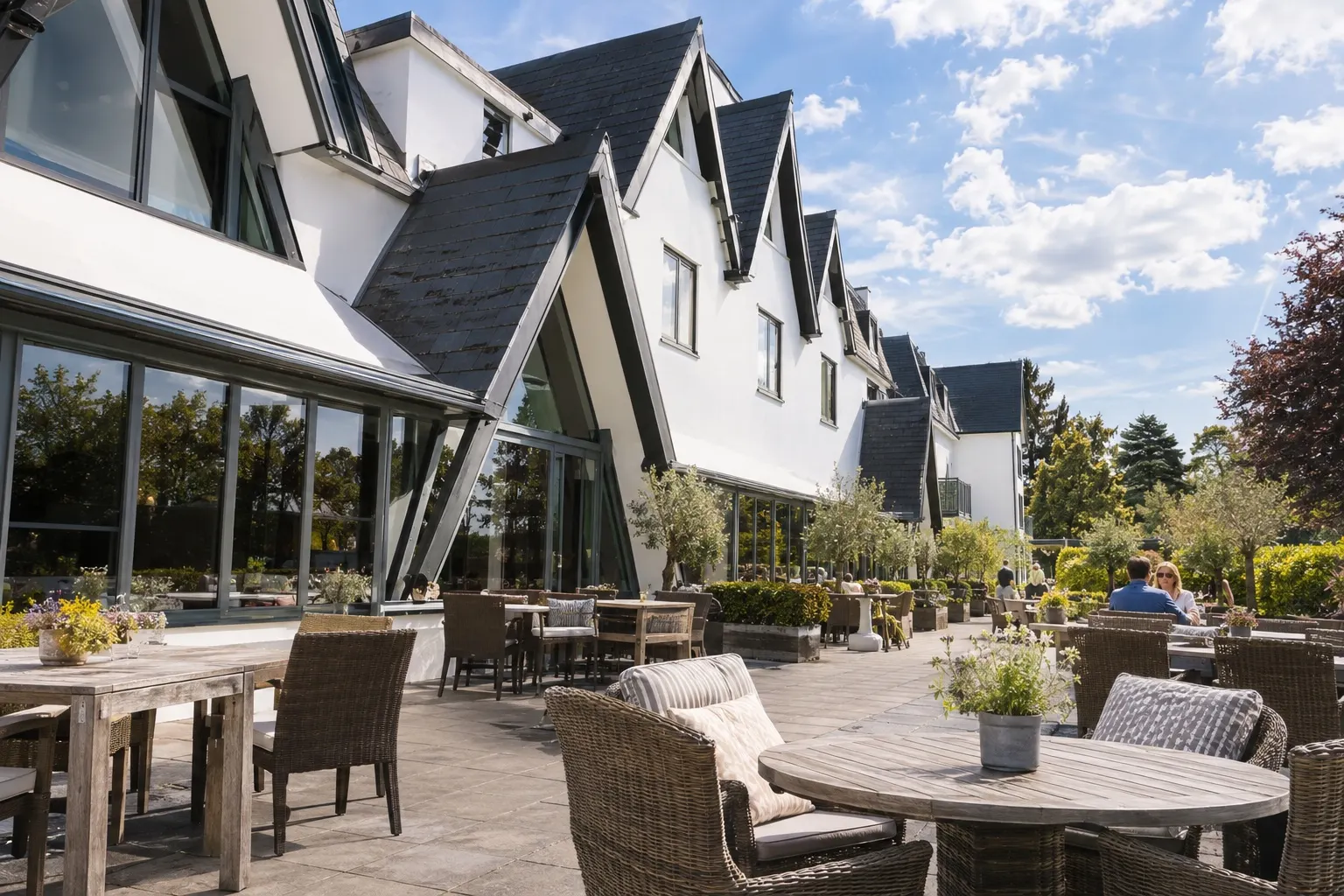 Illustrative sunlit terrace beside Coppid Beech Hotel's steep gabled facade
