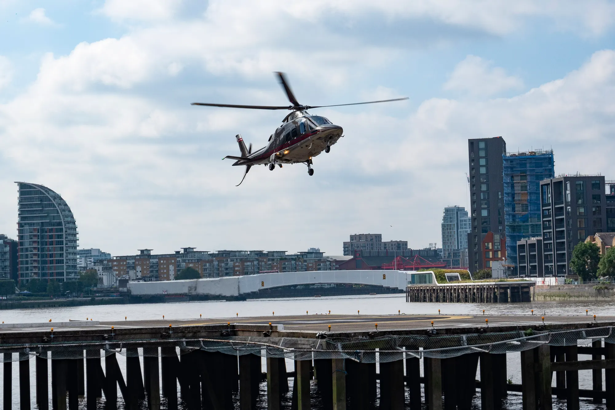 Helicopter leaving London Heliport's Thames-side pad in September 2021