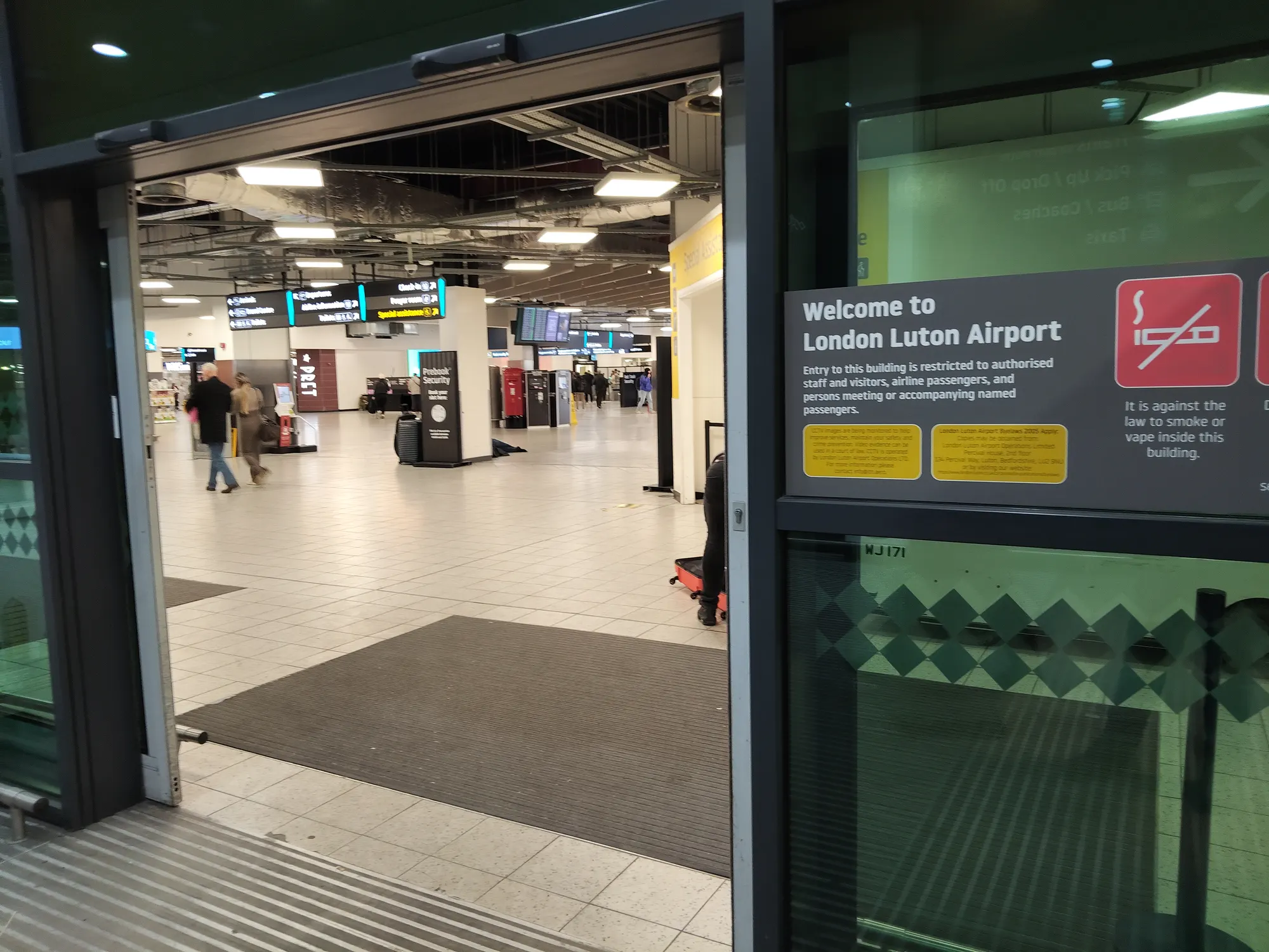 London Luton Airport public entrance near arrivals photographed in March 2025; not a current meeting-point instruction