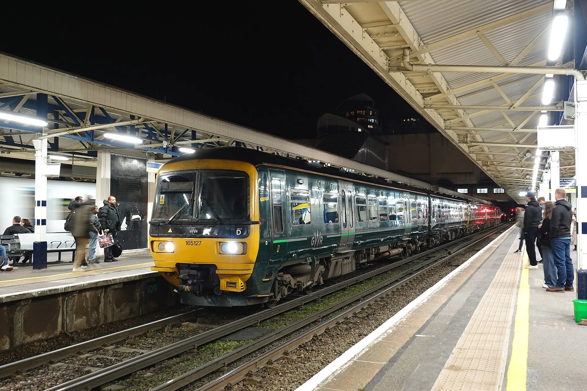 Passengers and a train at Woking station platform